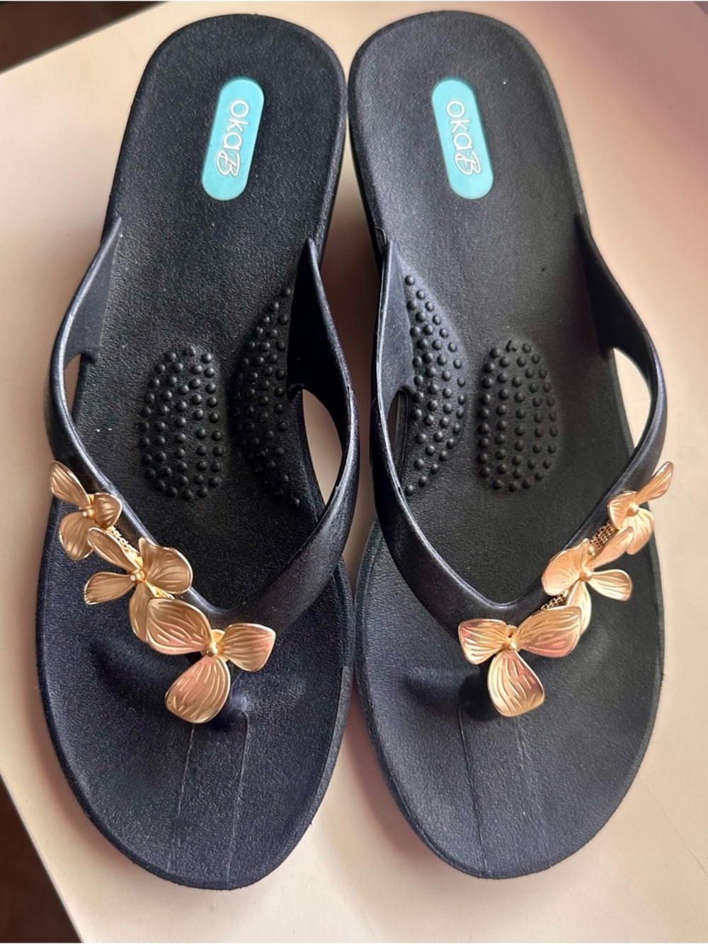 OKA b. Black Sandal Flip Flops with Gold Floral Embellishments